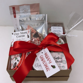 Gift box with festive items including a red ribbon on a white background